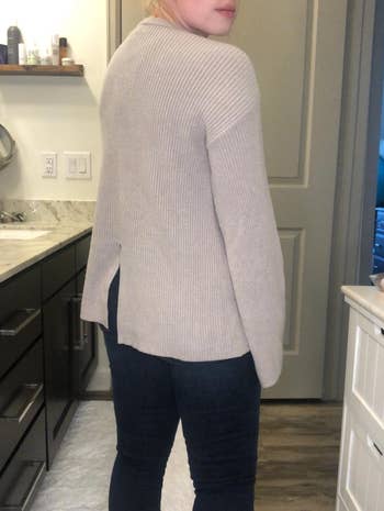 a reviewer wearing the sweater and showing the back slit