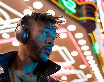 a model wearing the black Bose headphones outside at night