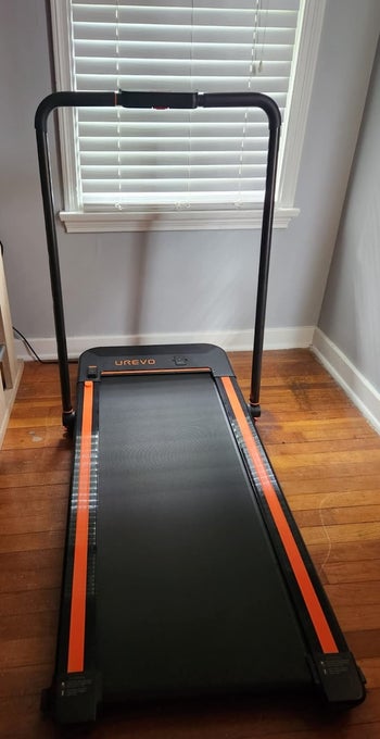reviewer photo of a black and orange treadmill