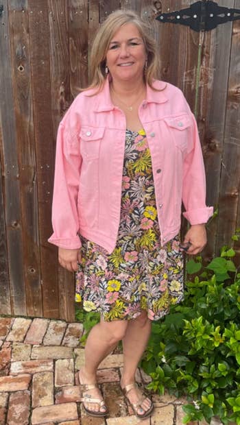 reviewer posing wearing the jacket in pink