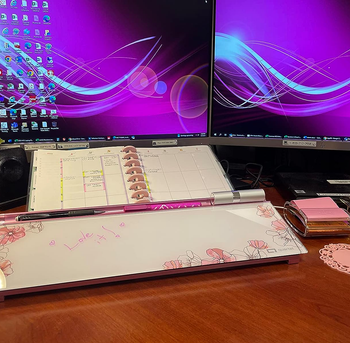 the pink and white whiteboard next to a desk