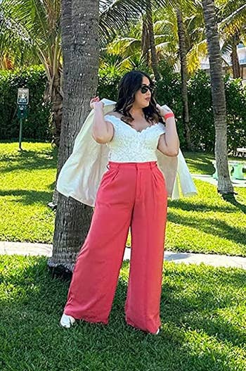 reviewer wearing the coral pants with a white top
