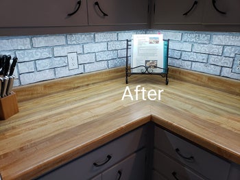 the same reviewer's after photo showing their cabinets with soft white lighting