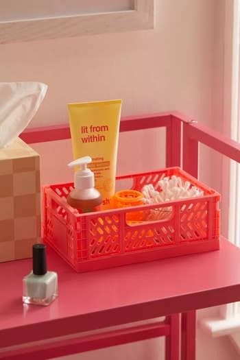 A close up of the pink crate holding bathroom essentials