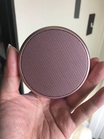 a reviewer holding the speaker in their hand