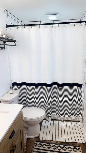 reviewer's bathroom with black and white striped shower curtain