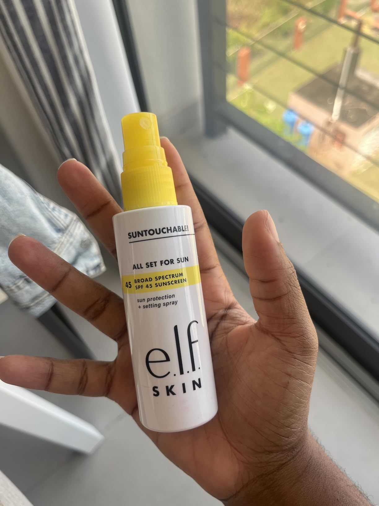 Person holding a vessel  of e.l.f. Skin 
