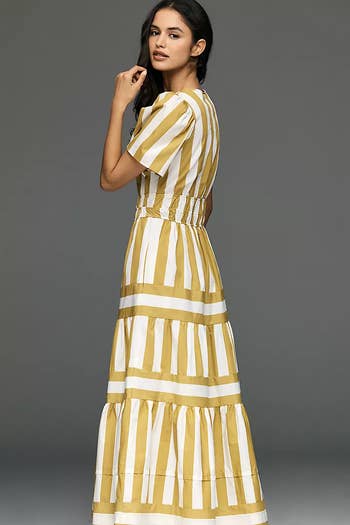 Person wearing a striped maxi formal  with puffed sleeves, looking implicit    shoulder, perfect  for a buying  article