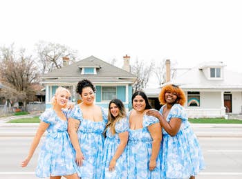 Five models pose together in blue and white dresses cloud print dresses