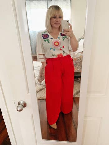 another reviewer wearing the red version with a white floral blouse tucked into it