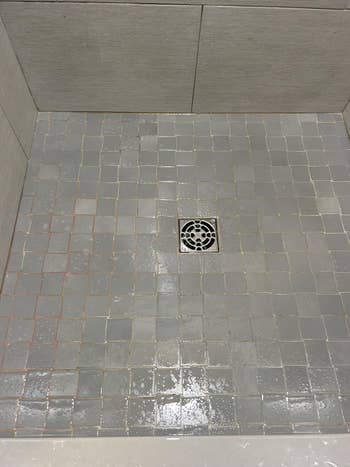 Shower floor with square tiles and a central drain, showcasing tile design suitable for bathroom renovation