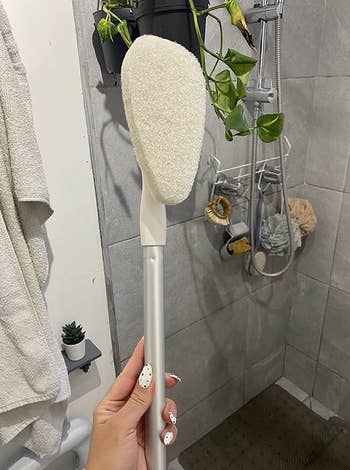 Reviewer holding a metal pole with a scrubber at the end of it 