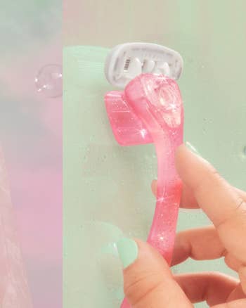 Hand holding a translucent pink razor against a pastel background, focusing on product design