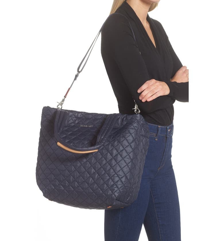 Model is holding the navy blue quilted tote bag