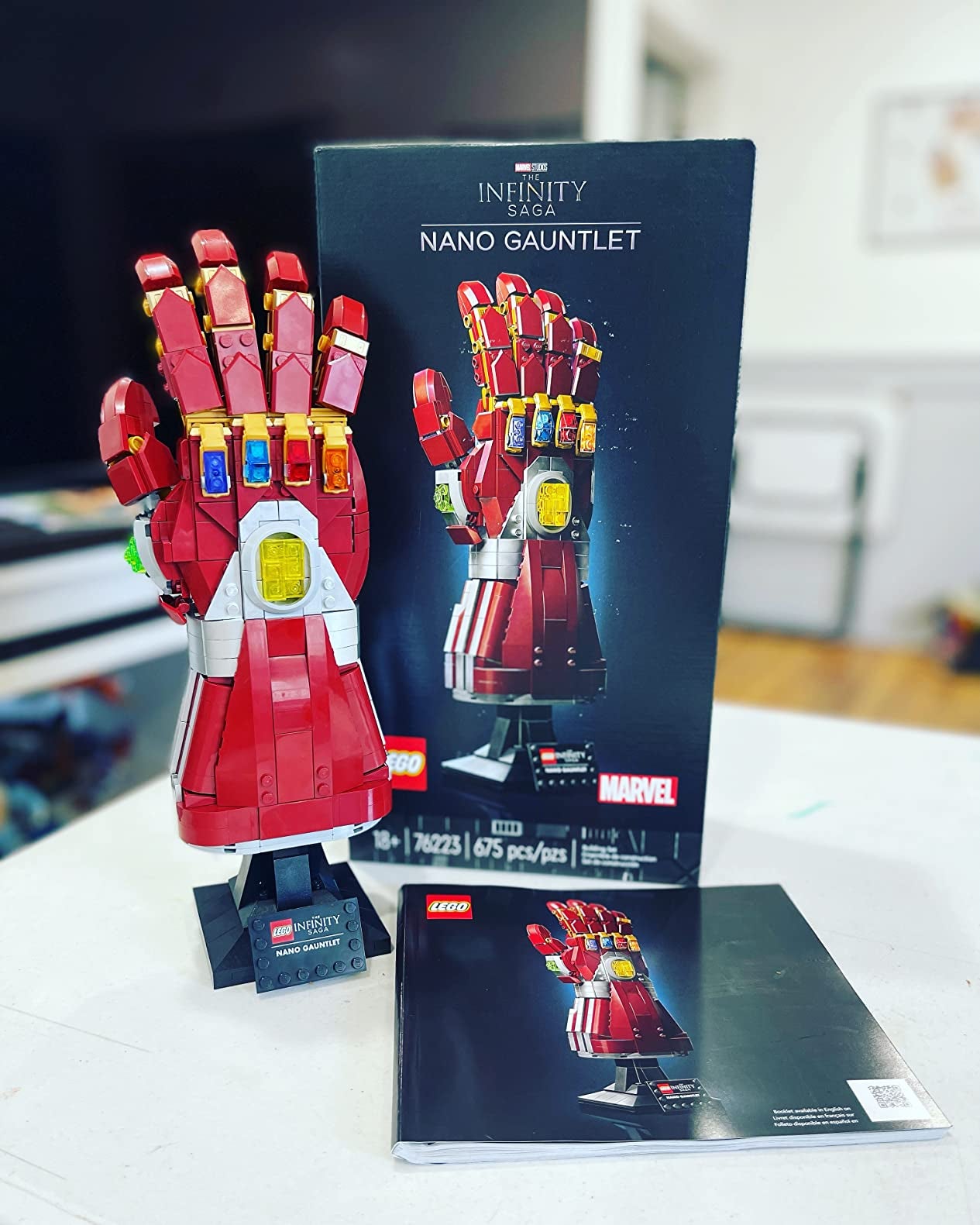 reviewer image of a built Lego gauntlet next to the box it came in