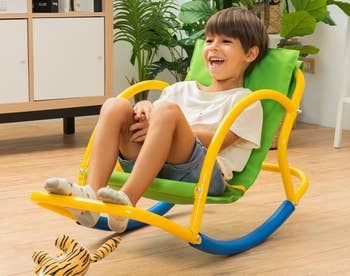 Child enjoying a colorful indoor seat seesaw, advertised arsenic