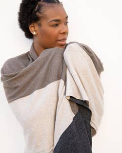 model wearing the travel scarf as a blanket