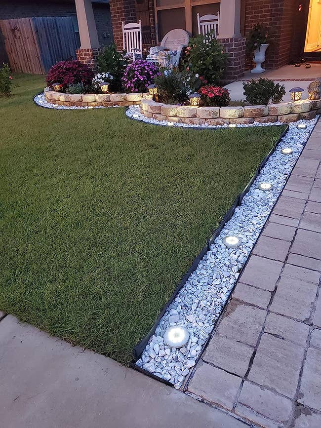 reviewer photo of the solar lights illuminating a yard and walkway