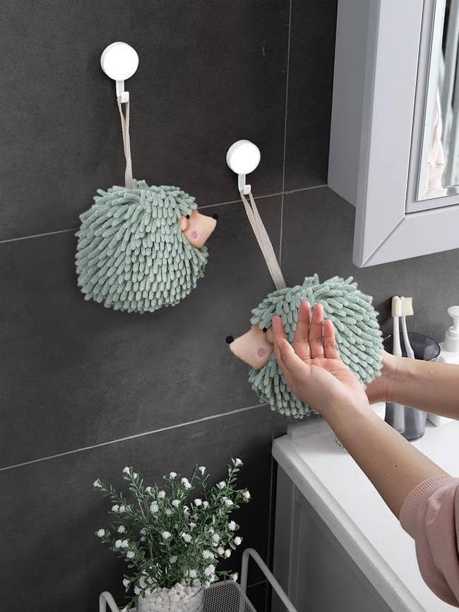 Person wiping their hands on a towel shaped like a hedgehog