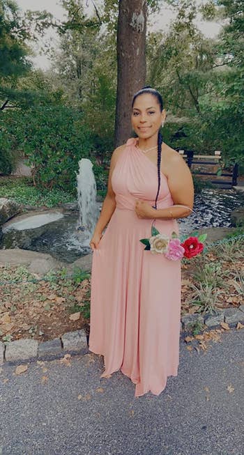 another reviewer wearing the peach color as a one-shoulder dress