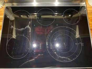 Electric stovetop with five burners and some visible smudges and stains on the surface