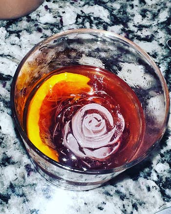 a rose-shaped ice cube in a cocktail