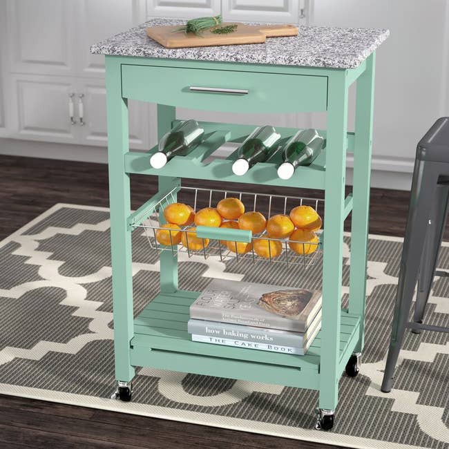 A mint kitchen cart with items on it