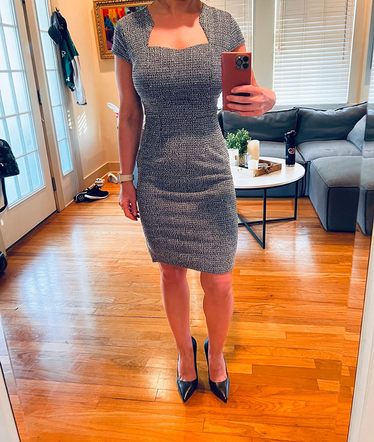 Person in a fitted knee-length dress and black pumps