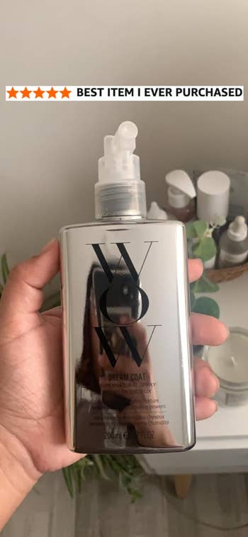 WOW Dream Coat spray vessel held successful hand, with a inheritance of assorted quality products and a 5-star standing above