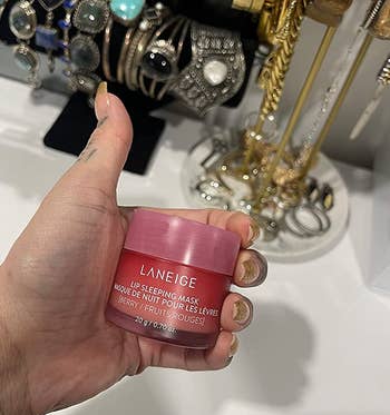 reviewer holding a pink container of the laneige lip sleeping mask