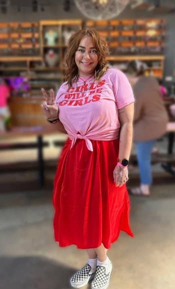 reviewer wearing the dress in red with pink t-shirt over it