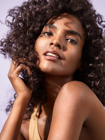 model with more defined dark brown curls after using the leave-in curl creme