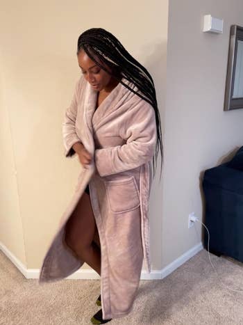 reviewer posing in long-sleeve, knee-length plush robe with pockets 
