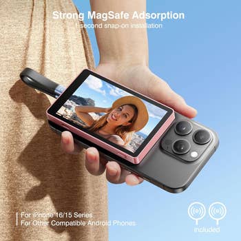 Model holds a telephone  with a pinkish  MagSafe camera attachment displaying their photo