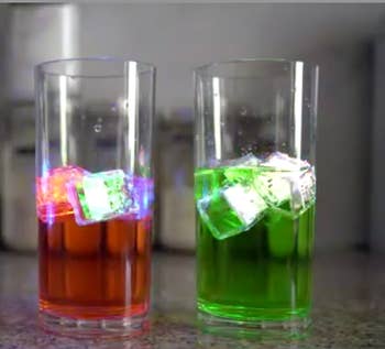 lit up ice cubes in a red and green cocktail 