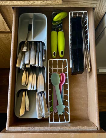 a reviewer showing the silverware sorter filled with forks, knives, and spoons