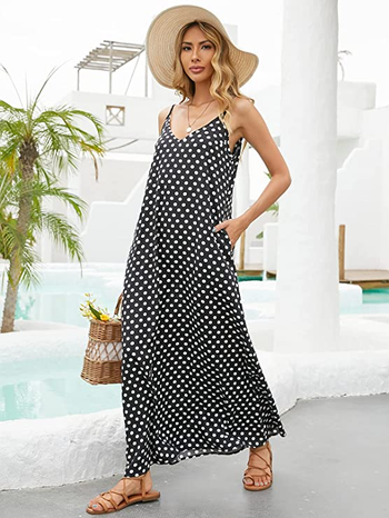 model in black dress with white polka dots with hand in pocket