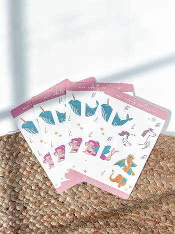 Various illustrated stickers with whimsical sea creatures and mermaids spread out on a textured surface