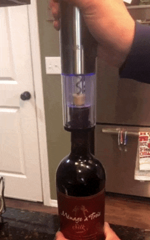 gif of reviewer using wine opener lifting a cork from out of the bottle