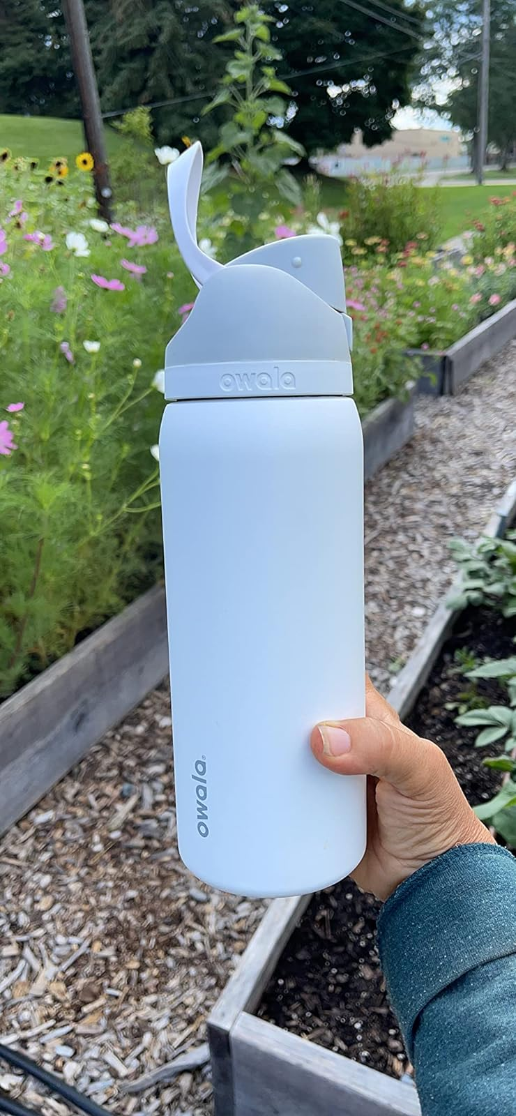 reviewer holding up the purple water bottle outside