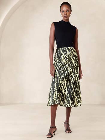 Model in a sleeveless top and patterned midi skirt