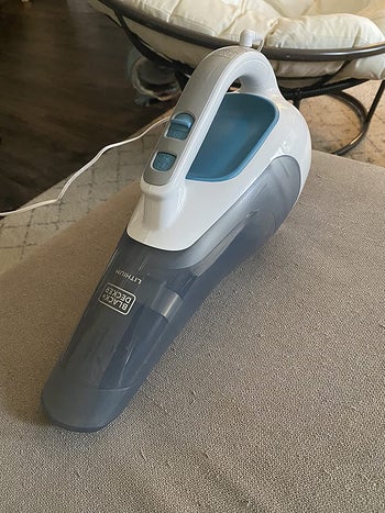 reviewer pic of the same handheld vacuum on a gray couch