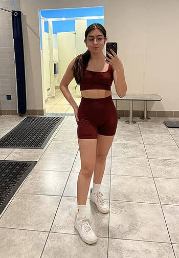 Reviewer is wearing the red short and top set with white sneakers
