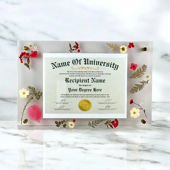 Decorative diploma show  with pressed flowers surrounding a customizable diploma holder connected  a marble surface, showcased for purchase