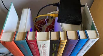 Reviewer's row of hardback books with open back, hiding router and wires