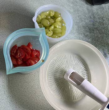 reviewer's containers of quartered grapes and cherry tomatoes next to the tool
