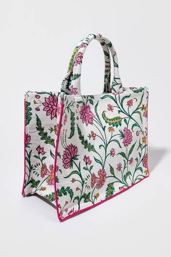 Floral embroidered fabric tote bag with dual handles, standing upright against a plain background