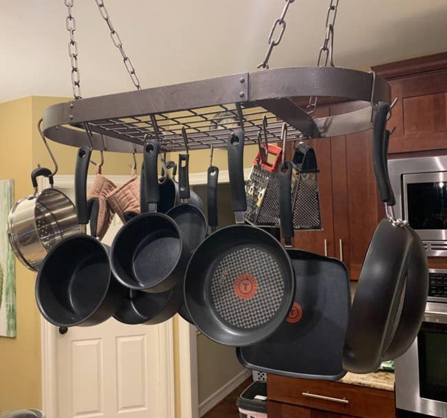 Hanging rack with assorted pots and pans organized successful a kitchen, showcasing cookware retention options