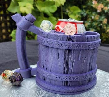 A drinking mug-shaped dice tower with a can inserted 