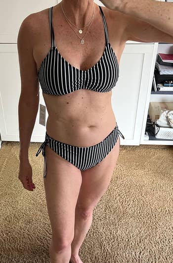 Woman in a striped bikini posing indoors, relevant to an article on swimwear shopping